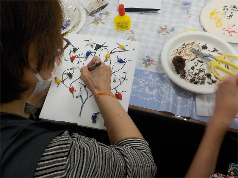 パネル上の小鳥パーツに細かな装飾や表情を描き込んでいく様子