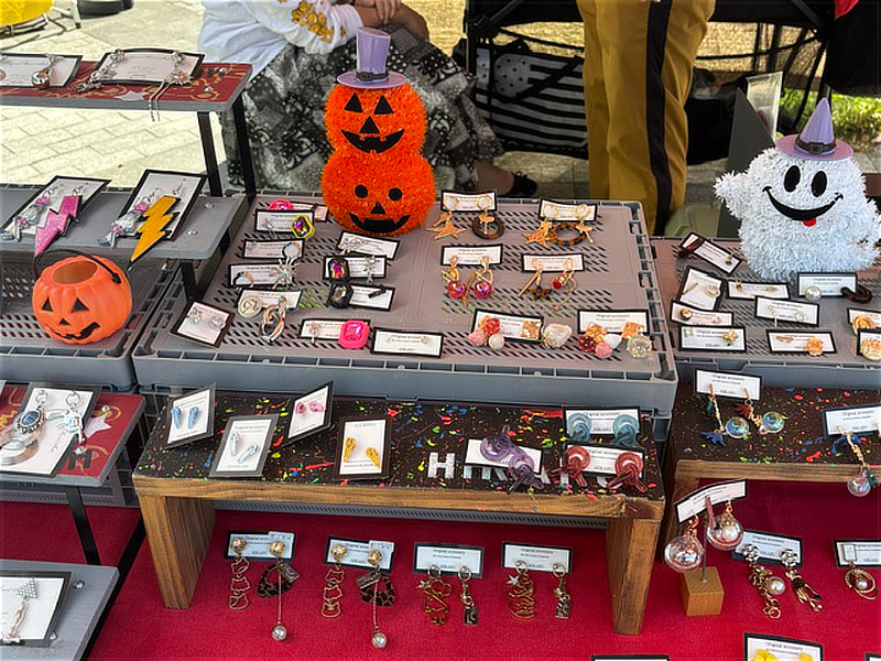 SAKURAZAKAマルシェのアクセサリー販売ブース。ハロウィンの飾りとともに、ピアスやイヤリングなどの手作りアクセサリーが並ぶ。